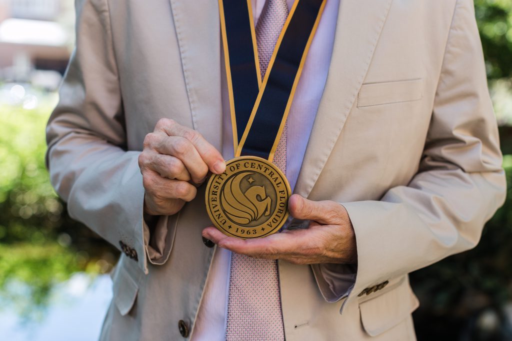 Kenneth Hanson holds the medal for his invested professorship