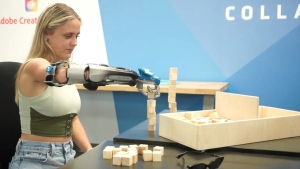 A woman with a prosthetic arm grabs a building block.