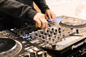 Two hands using DJ sound board.
