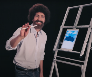 Chad Cameron, dressed as famous painter Bob Ross, hosts a digital painting demonstration.