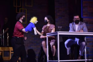 A puppet bursts into a scene from "First Date" featuring Andrew Lofredo, Kayla Rose Ginty and Woodrow Jackson Helms