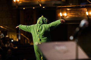 A student dressed as a dinosaur for the Inclusive Knights Concert Series concert.